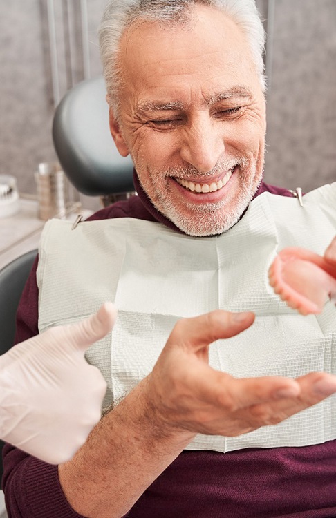 a dentist showing a patient their new dentures 